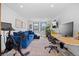 Cozy living room with a workspace featuring an L-shaped blue sofa and a large window for natural light at 4454 Utica St, Denver, CO 80212