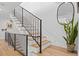 Modern staircase with wooden steps, sleek black metal railings, and tasteful decor against white walls at 4454 Utica St, Denver, CO 80212