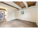 Basement space showcasing neutral carpet, wood ceilings, and bright, white-painted walls at 9349 E Chenango Ave, Greenwood Village, CO 80111