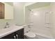 Bathroom featuring vanity, toilet and shower-tub combo with white tiling at 9349 E Chenango Ave, Greenwood Village, CO 80111