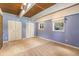 Bedroom with wood ceilings, neutral carpet, white closet doors and a large window at 9349 E Chenango Ave, Greenwood Village, CO 80111
