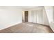 A bedroom with neutral carpet, a large window, and bi-fold closet doors, bathed in soft light at 9349 E Chenango Ave, Greenwood Village, CO 80111