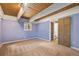 Bedroom with a wood-beamed ceiling, neutral carpet, and an open door to the stairs at 9349 E Chenango Ave, Greenwood Village, CO 80111