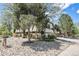 A multi-level home with mature trees, unique architectural details, and rock landscaping at 9349 E Chenango Ave, Greenwood Village, CO 80111
