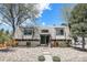 Inviting home featuring a unique roofline, stone landscaping, and a serene, tree-lined setting at 9349 E Chenango Ave, Greenwood Village, CO 80111