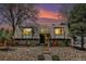 Inviting home featuring a unique roofline, stone landscaping, and a serene, tree-lined setting at 9349 E Chenango Ave, Greenwood Village, CO 80111