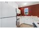 The kitchen features white cabinets and stainless steel appliances against a bright red wall with a window at 9349 E Chenango Ave, Greenwood Village, CO 80111