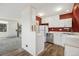 Cozy kitchen with stainless steel appliances and white cabinets against a red wall, with wood-style floors at 9349 E Chenango Ave, Greenwood Village, CO 80111