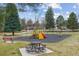 Bright community playground offers a slide, swings, picnic tables and is surrounded by mature trees and grassy areas at 176 W Elm St, Elizabeth, CO 80107