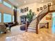 Elegant foyer with curved staircase, soaring ceilings, and travertine tile flooring at 13970 Craig Way, Broomfield, CO 80020