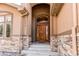 Inviting entryway features a grand arched doorway, stone accents, and a beautifully crafted wood door at 13970 Craig Way, Broomfield, CO 80020
