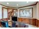 A lovely home office area with a dark wood desk, wood trim, and a world map hanging on the wall at 13970 Craig Way, Broomfield, CO 80020