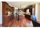 A spacious kitchen with dark wood cabinets, an island with bar stool seating, and hardwood flooring at 13970 Craig Way, Broomfield, CO 80020