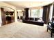 Inviting living room featuring a dark leather sofa, large windows with drapes, and direct access to the kitchen at 13970 Craig Way, Broomfield, CO 80020