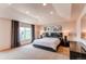 Bright main bedroom with a large bed, dark wood furniture, recessed lighting, and large window at 13970 Craig Way, Broomfield, CO 80020
