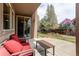 Inviting outdoor patio area with comfortable red seating and a stylish wooden table, perfect for enjoying the serene backyard view at 13970 Craig Way, Broomfield, CO 80020