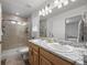Bright bathroom featuring double sinks with granite countertops and a glass-enclosed shower at 4060 N Rome St, Aurora, CO 80019