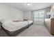 Well-lit bedroom with neutral colors, carpet flooring, and a large window for natural light at 4060 N Rome St, Aurora, CO 80019
