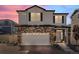 Charming two-story home featuring stone accents, white siding, and a two-car garage during a colorful dusk at 4060 N Rome St, Aurora, CO 80019