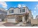 Beautiful two-story home showcasing a stone facade, white siding, and a well-manicured front yard under a sunny sky at 4060 N Rome St, Aurora, CO 80019