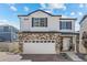 Beautiful two-story home showcasing a stone facade, white siding, and a well-manicured front yard under a sunny sky at 4060 N Rome St, Aurora, CO 80019