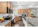 Modern kitchen with stainless steel appliances, wood cabinets, and granite countertops at 4060 N Rome St, Aurora, CO 80019