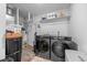 Modern laundry room with front loading washer and dryer, plus storage shelves and equipment at 4060 N Rome St, Aurora, CO 80019