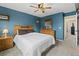Cozy bedroom with blue walls, carpet flooring, wood furniture, and a comfortable queen-sized bed at 9816 Garwood St, Littleton, CO 80125