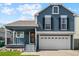 Charming two-story home with blue siding, white garage door, and manicured lawn at 9816 Garwood St, Littleton, CO 80125