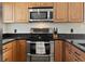 Well-equipped kitchen with stainless steel appliances, granite countertops, and wooden cabinets at 9816 Garwood St, Littleton, CO 80125