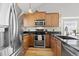 Charming kitchen featuring stainless steel appliances, wood cabinets and granite countertops at 9816 Garwood St, Littleton, CO 80125