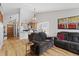 Open-concept living room boasts hardwood floors, an adjacent kitchen view, and natural lighting at 9816 Garwood St, Littleton, CO 80125