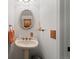 Charming powder room with a pedestal sink, decorative mirror, and tasteful accents at 9816 Garwood St, Littleton, CO 80125