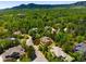 An aerial view of a residential neighborhood showcases the homes and lush tree canopy against a mountain backdrop at 2345 Spotswood Pl, Boulder, CO 80304