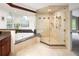 Luxurious bathroom with glass shower, soaking tub, granite countertops, and ample natural light at 2345 Spotswood Pl, Boulder, CO 80304