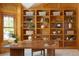 Stylish home office featuring wood paneling, custom built-in shelving, and a large work desk at 2345 Spotswood Pl, Boulder, CO 80304