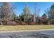 This grassy backyard is surrounded by a wooden fence and mature trees at 2345 Spotswood Pl, Boulder, CO 80304