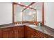 Bathroom featuring a large granite counter with double sinks, wood cabinetry, and a large mirror at 2345 Spotswood Pl, Boulder, CO 80304