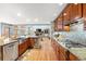 Spacious kitchen featuring stainless steel appliances, granite countertops, and wood cabinets, leading to the living room at 2345 Spotswood Pl, Boulder, CO 80304