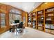 Inviting home office with custom built-in shelving, a large window, and wood paneled walls at 2345 Spotswood Pl, Boulder, CO 80304