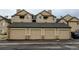Picture of the complex garages with individual doors and stone accents on a cloudy day at 8369 S Independence Cir # 205, Littleton, CO 80128