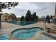 Community pool and hot tub covered for the winter, surrounded by a secure fence and landscaping at 8369 S Independence Cir # 205, Littleton, CO 80128