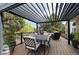 Outdoor deck with a metal awning, dining table, and additional lounge seating with views of the yard at 740 W Lancers Ct, Monument, CO 80132