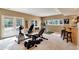 Spacious basement gym area with exercise equipment, a bar with stools, and natural light from double doors at 740 W Lancers Ct, Monument, CO 80132