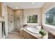 Bright bathroom featuring a modern soaking tub, glass shower, and large window at 740 W Lancers Ct, Monument, CO 80132