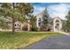 Charming home with mature trees and landscaping, large windows, and a covered patio area at 740 W Lancers Ct, Monument, CO 80132