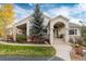 Inviting single-Gathering home with charming stucco exterior, mature landscaping, and covered porch at 740 W Lancers Ct, Monument, CO 80132