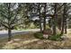 Landscaped front yard with a swing bench nestled among mature trees at 740 W Lancers Ct, Monument, CO 80132