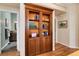 Hallway with a built-in bookcase, hardwood floors, and access to a bathroom at 740 W Lancers Ct, Monument, CO 80132