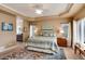 Large bedroom with en suite bathroom featuring tray ceilings, carpet, and lots of natural light at 740 W Lancers Ct, Monument, CO 80132